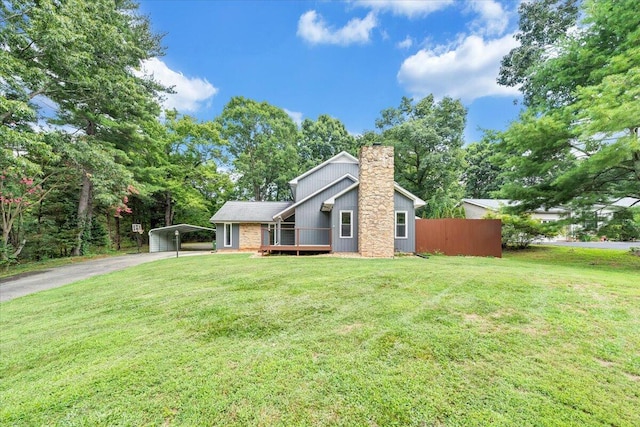 view of front of home featuring a chimney, a front lawn, aphalt driveway, and a detached carport