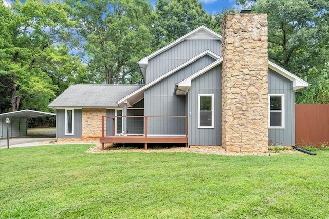 view of front of property with roof with shingles, a chimney, a front yard, fence, and a carport