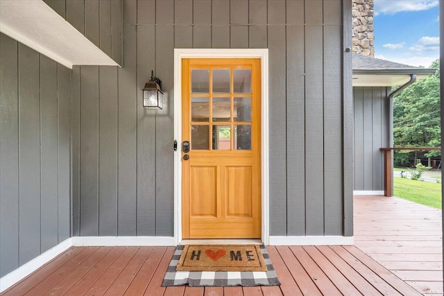 view of exterior entry featuring roof with shingles