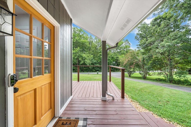 wooden deck featuring a porch and a yard