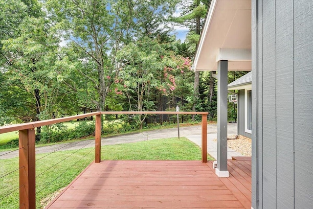 wooden terrace featuring a lawn