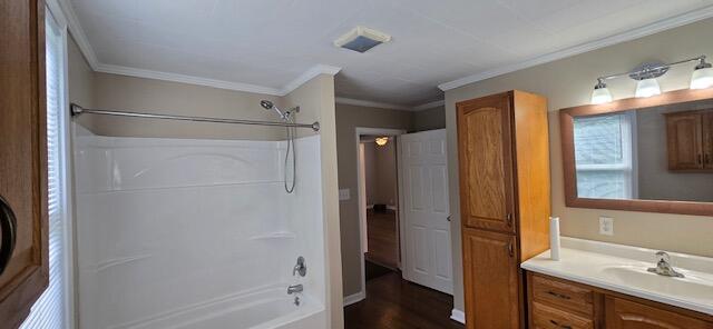 bathroom with wood-type flooring, washtub / shower combination, ornamental molding, and vanity