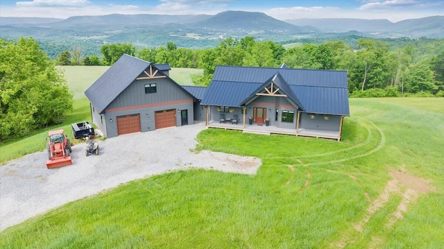 view of front facade featuring a mountain view, a front yard, and a garage