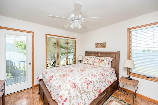 bedroom with multiple windows, ceiling fan, access to outside, and light parquet floors