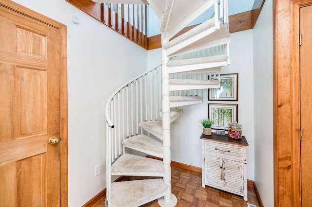 stairway with a high ceiling and parquet floors