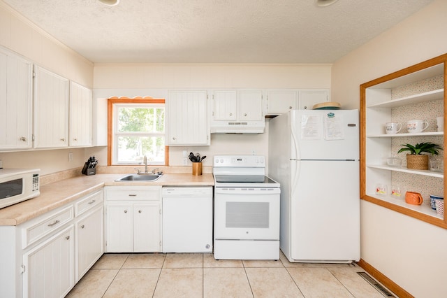 kitchen with light tile floors, white cabinetry, sink, white appliances, and a textured ceiling