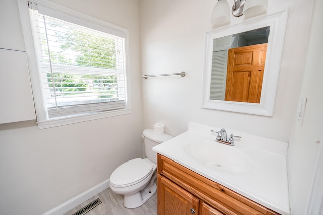 bathroom with tile flooring, toilet, and vanity