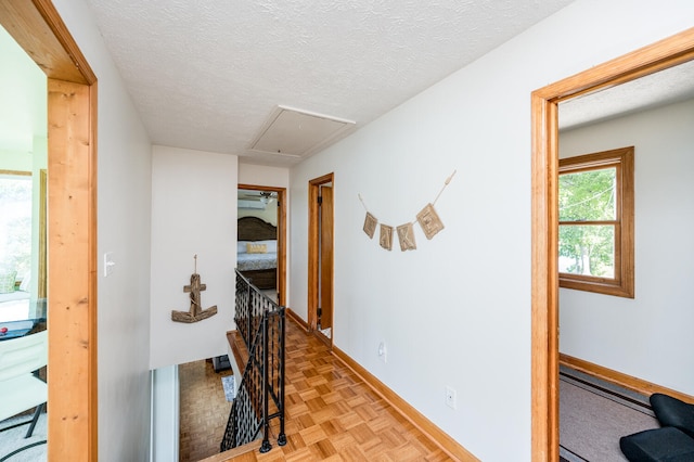 hall with a textured ceiling and light parquet flooring