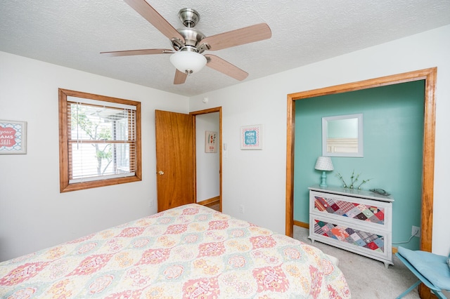 bedroom featuring a textured ceiling, ceiling fan, and carpet floors