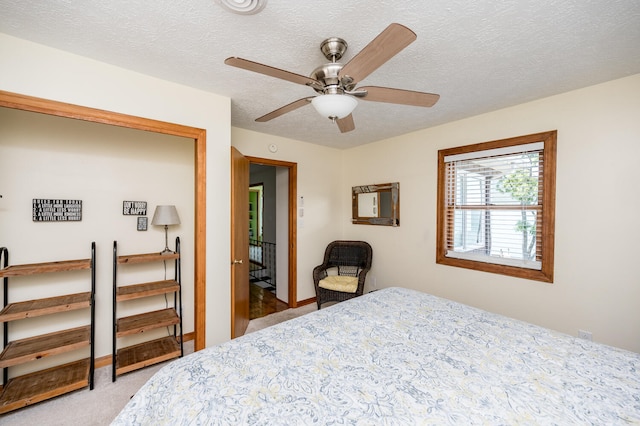 bedroom with carpet flooring, ceiling fan, and a textured ceiling