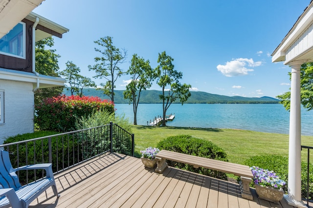 wooden terrace featuring a water view and a yard