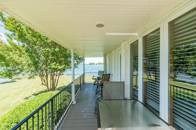 wooden terrace with a lawn and a water view