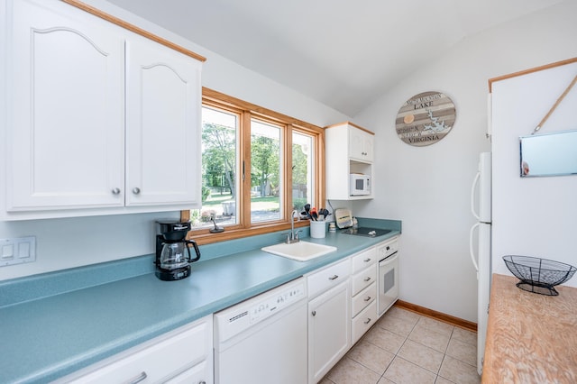 kitchen with white appliances, sink, white cabinets, and vaulted ceiling