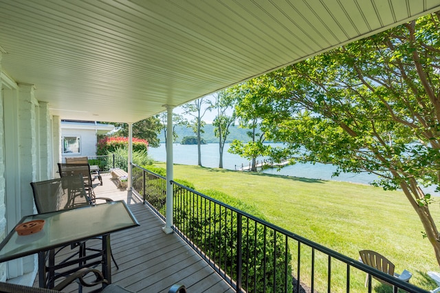 wooden terrace with a lawn and a water view