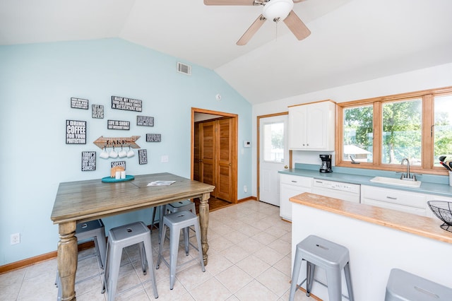 kitchen with ceiling fan, vaulted ceiling, light tile floors, sink, and white cabinetry