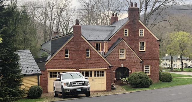 english style home featuring a garage