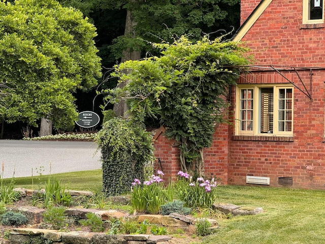 view of side of home with a yard