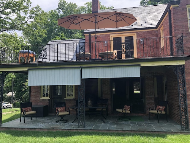 rear view of property with a patio area and a balcony