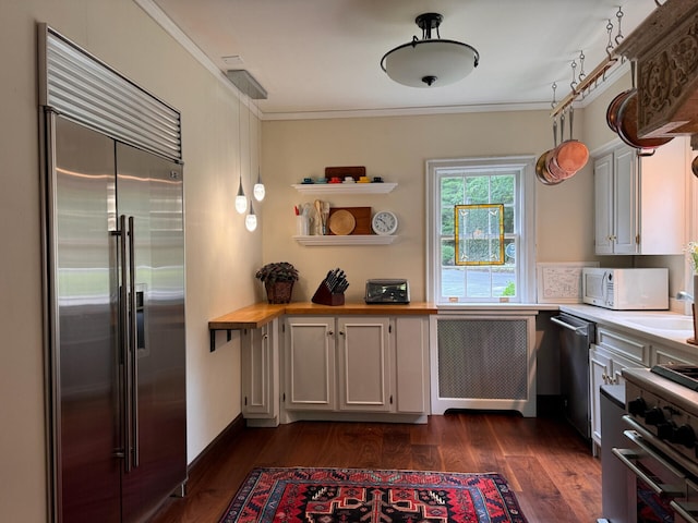 kitchen featuring radiator, butcher block counters, dark wood-type flooring, high quality appliances, and ornamental molding