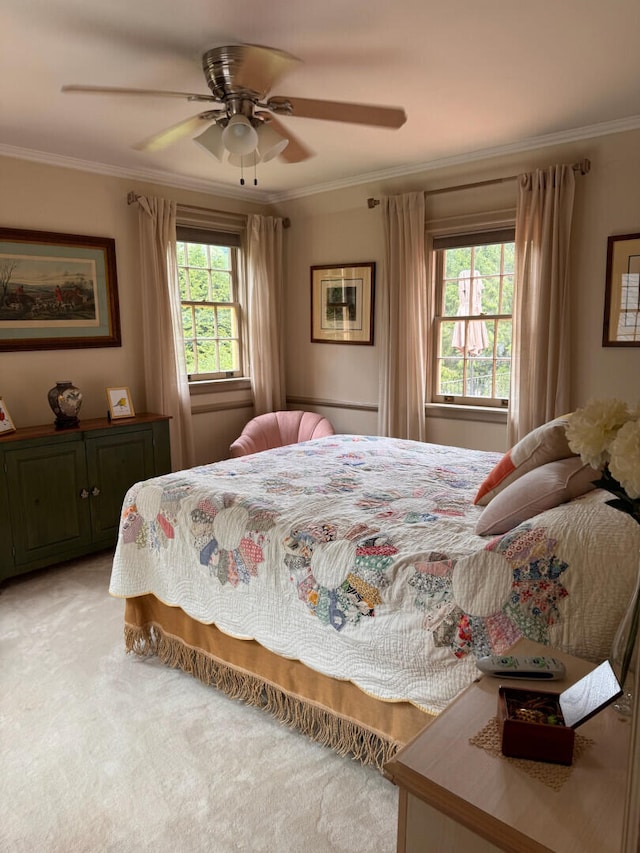 bedroom with multiple windows, ceiling fan, crown molding, and light carpet