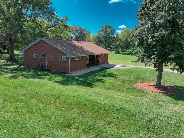 view of side of property featuring central air condition unit and a yard