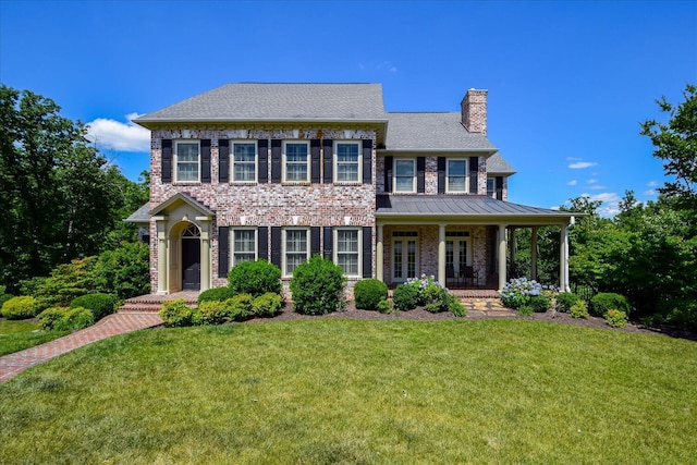 colonial-style house featuring a front lawn