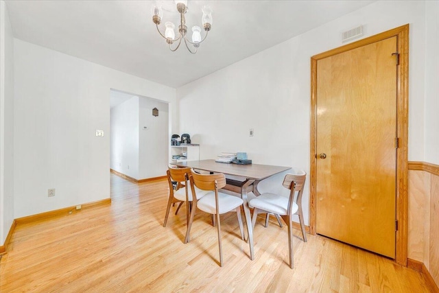 dining area featuring a notable chandelier and light wood-type flooring