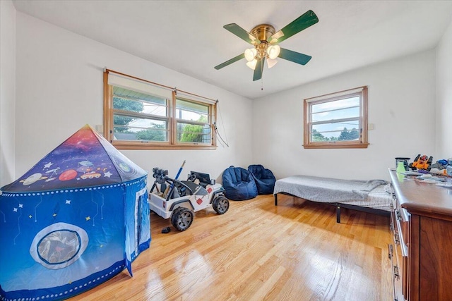 playroom with wood-type flooring and ceiling fan