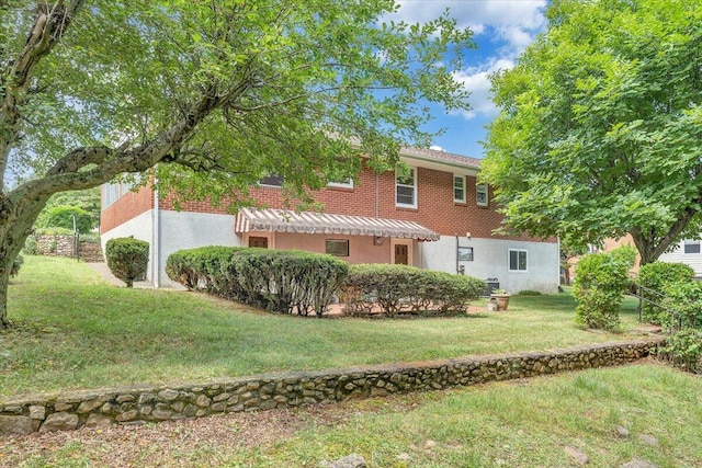 rear view of house featuring a yard