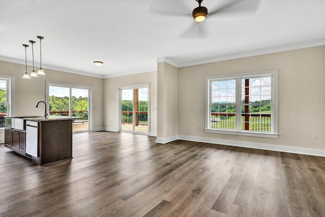 unfurnished living room with ceiling fan, dark hardwood / wood-style flooring, and ornamental molding