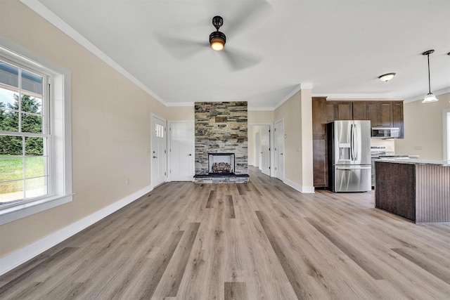 unfurnished living room with a fireplace, ceiling fan, plenty of natural light, and ornamental molding