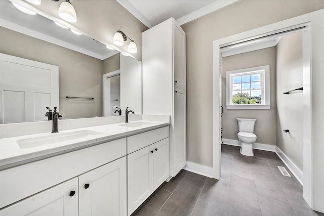 bathroom with vanity, toilet, and ornamental molding