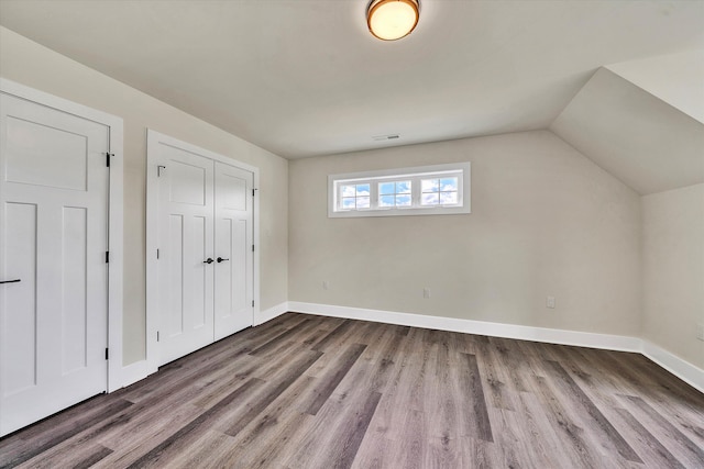 bonus room with lofted ceiling and wood-type flooring