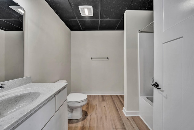 full bathroom featuring shower / bathing tub combination, vanity, hardwood / wood-style flooring, and toilet