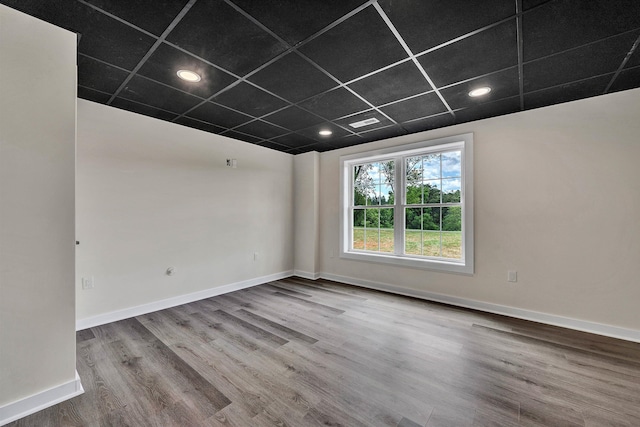 unfurnished room with a paneled ceiling and hardwood / wood-style floors