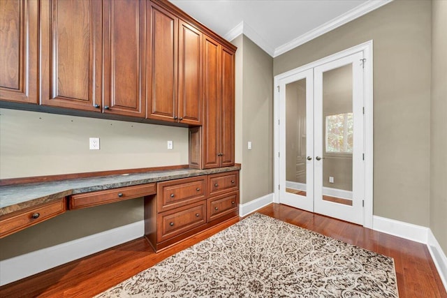 office with french doors, ornamental molding, dark hardwood / wood-style flooring, and built in desk