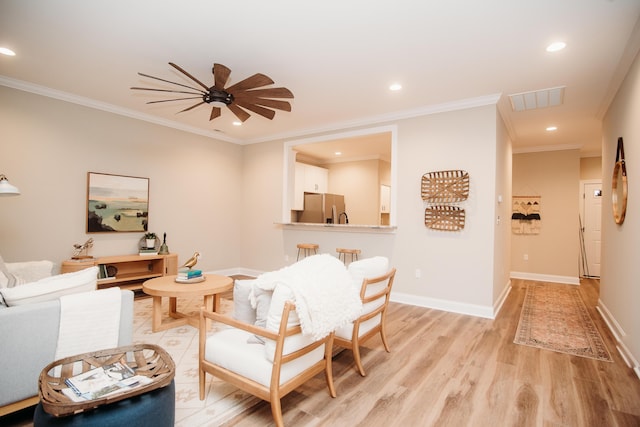 living room featuring ceiling fan, light hardwood / wood-style floors, and ornamental molding