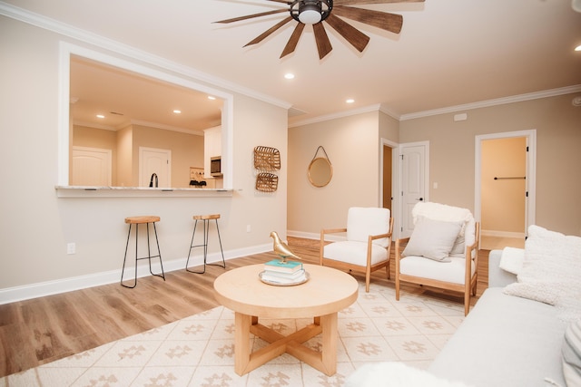 living room with ceiling fan, light wood-type flooring, and ornamental molding