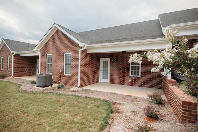 view of front facade featuring central AC, a front lawn, and a patio