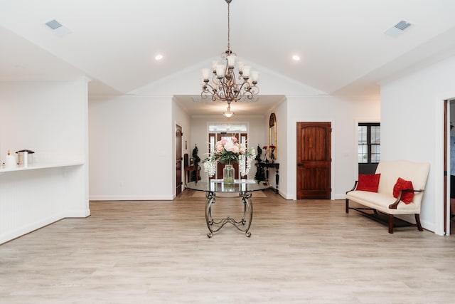 interior space featuring crown molding, a chandelier, vaulted ceiling, and light wood-type flooring