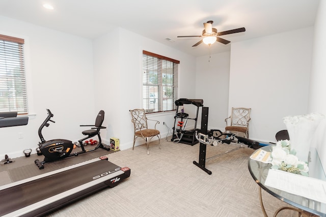 exercise room with light carpet and ceiling fan