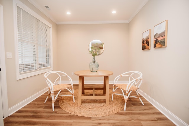 dining room with wood-type flooring and crown molding