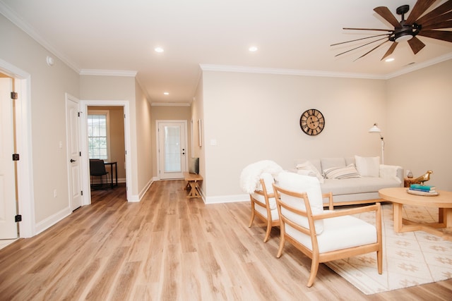 living room featuring light hardwood / wood-style floors, ceiling fan, and ornamental molding