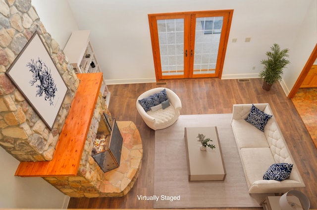 living area featuring baseboards, visible vents, wood finished floors, and french doors