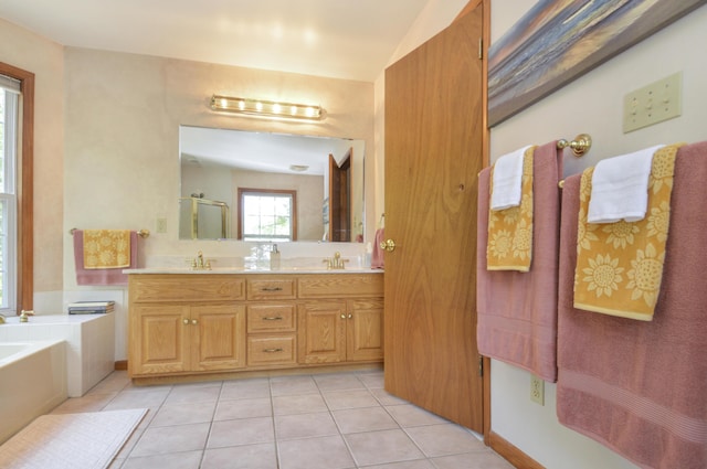 bathroom with double vanity, a sink, a bath, and tile patterned floors