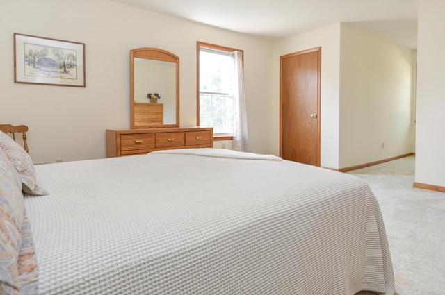 bedroom with light carpet and baseboards