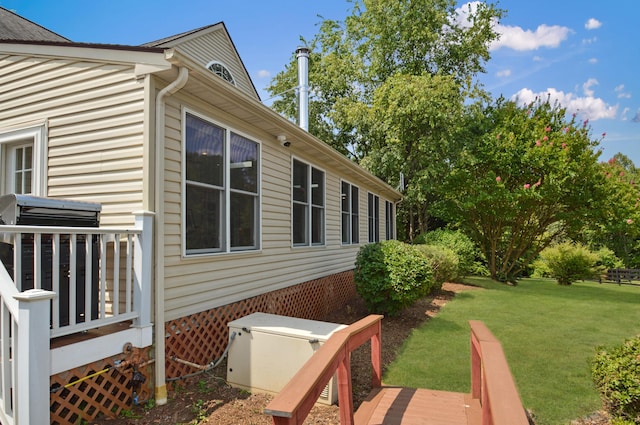 view of home's exterior with a wooden deck and a yard