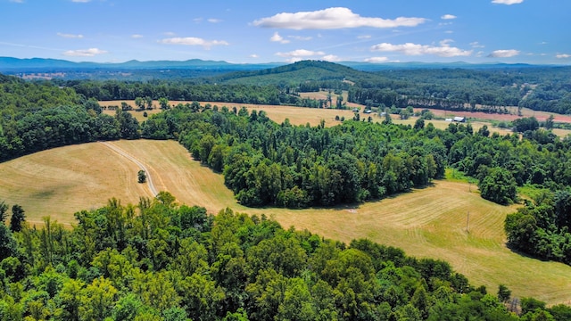 birds eye view of property featuring a mountain view, a wooded view, and a rural view