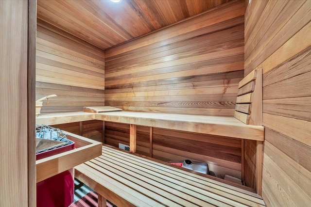 view of sauna featuring wooden ceiling and wooden walls