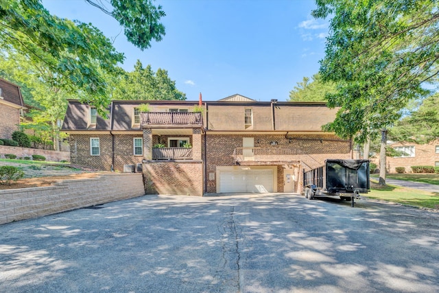 view of front of house with a balcony, a garage, and central air condition unit